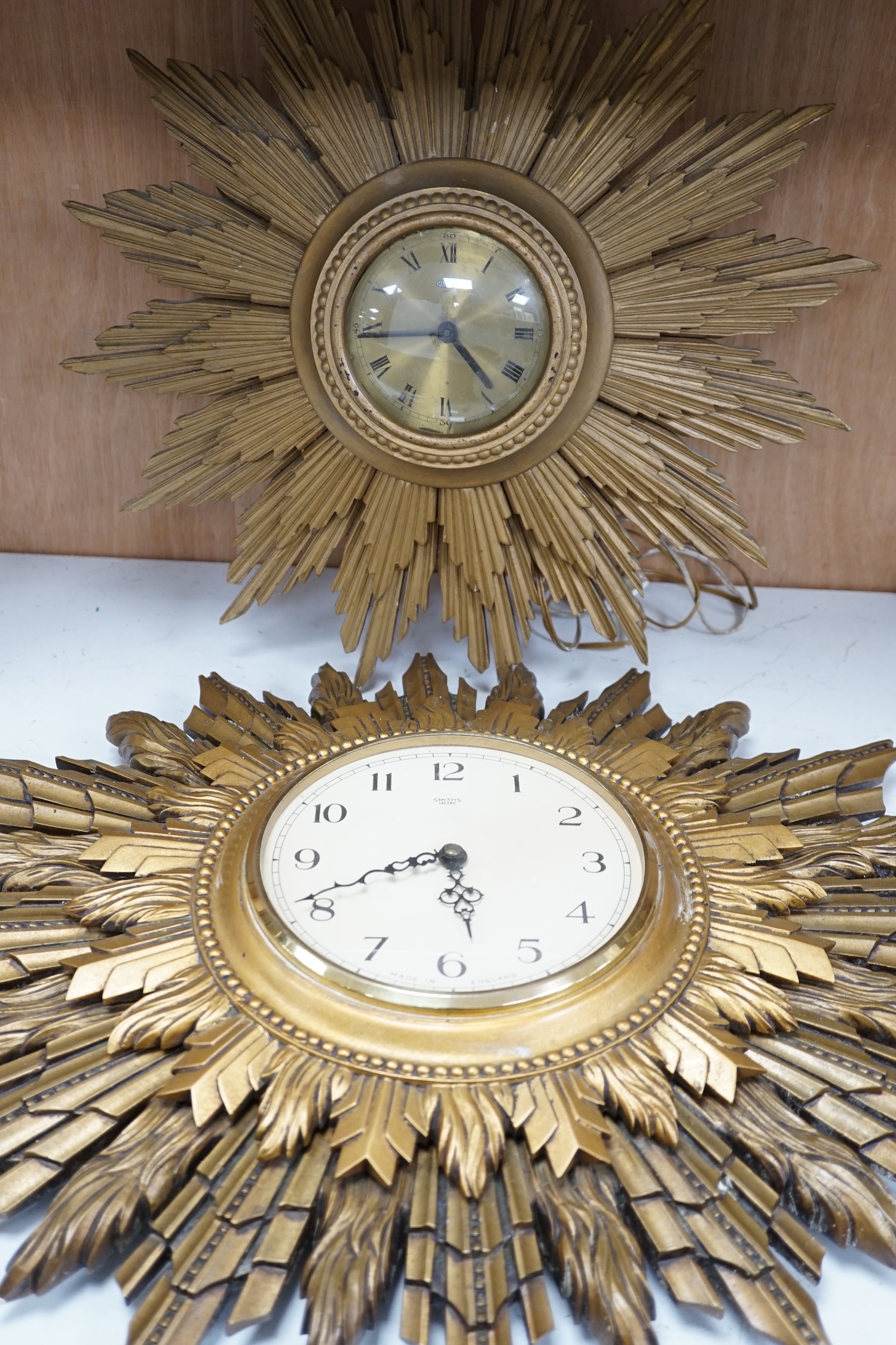 A Smiths sunburst wall clock and a similar Metamec clock, Smith clock 66cm wide